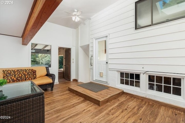 living room featuring wood-type flooring, ceiling fan, and beam ceiling