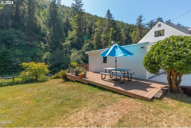 rear view of house with a wooden deck and a yard