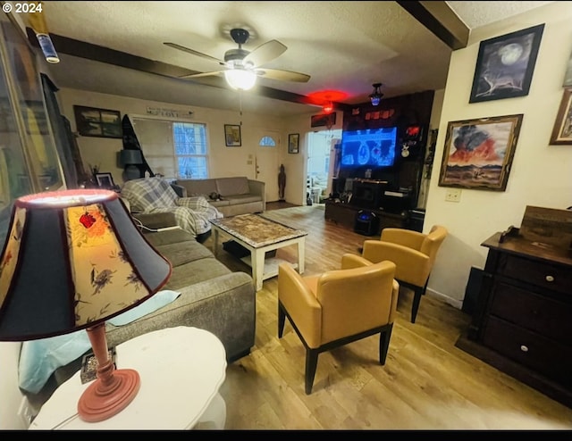 living room featuring a textured ceiling, light wood-type flooring, and ceiling fan