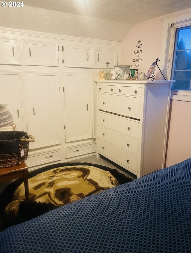 bedroom featuring a textured ceiling, a closet, and lofted ceiling