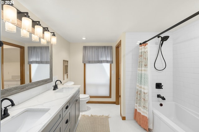 full bathroom with dual bowl vanity, shower / bath combo, a wealth of natural light, and toilet