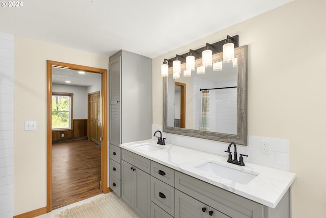 bathroom with oversized vanity, hardwood / wood-style flooring, and double sink