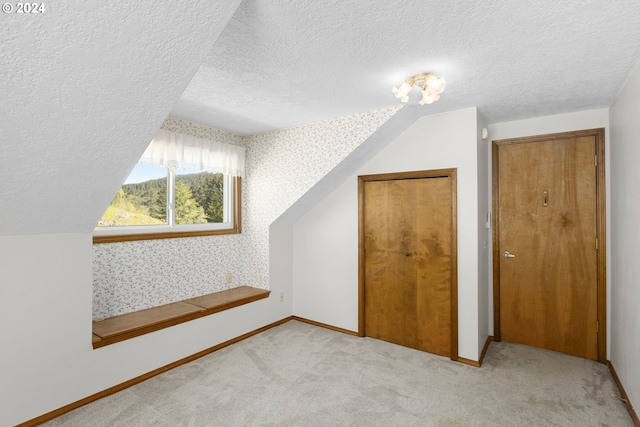 bonus room with a textured ceiling, carpet, and vaulted ceiling