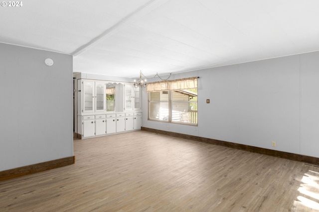 unfurnished living room featuring light hardwood / wood-style floors and an inviting chandelier