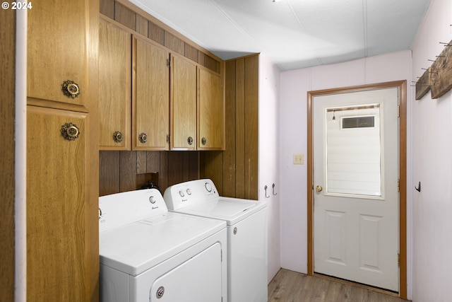 laundry area featuring light hardwood / wood-style floors, cabinets, washer and clothes dryer, and washer hookup