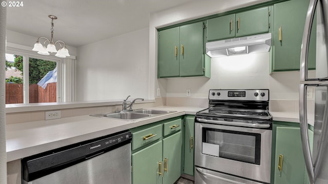 kitchen featuring appliances with stainless steel finishes, green cabinetry, an inviting chandelier, sink, and kitchen peninsula