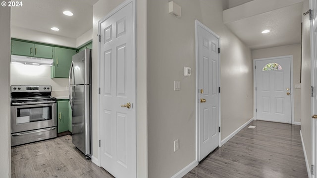 kitchen featuring a textured ceiling, green cabinets, light hardwood / wood-style floors, and stainless steel appliances