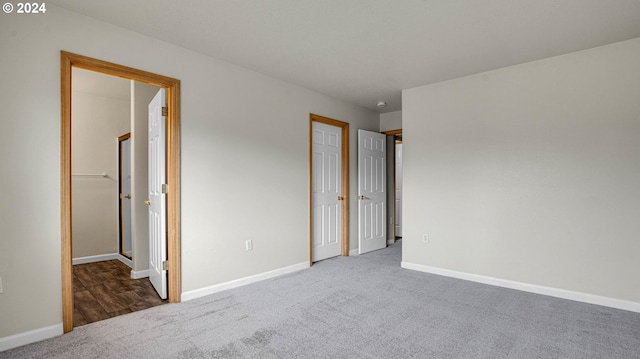 unfurnished bedroom with dark carpet