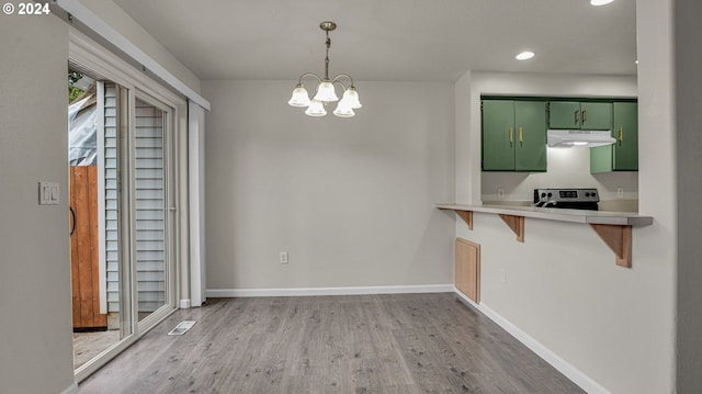 unfurnished dining area featuring light wood-type flooring and a chandelier