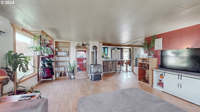 living room with a wall mounted air conditioner and hardwood / wood-style flooring