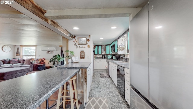 kitchen with white cabinets, an AC wall unit, stainless steel refrigerator, sink, and dishwasher