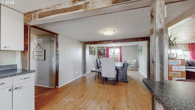 dining room with light hardwood / wood-style floors and a textured ceiling