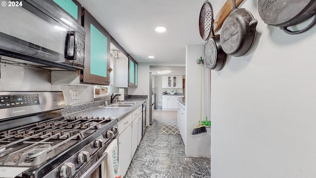 kitchen with white cabinetry, sink, stainless steel appliances, and backsplash