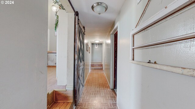 hall featuring a barn door and light parquet floors