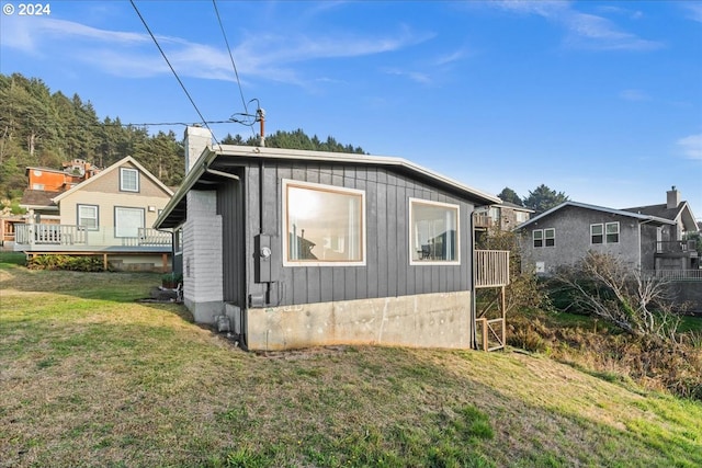 view of home's exterior featuring a lawn and a deck