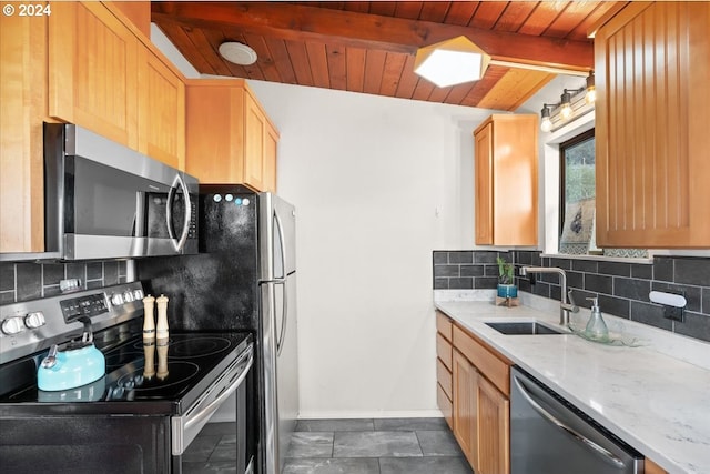 kitchen with light stone counters, decorative backsplash, beam ceiling, appliances with stainless steel finishes, and sink