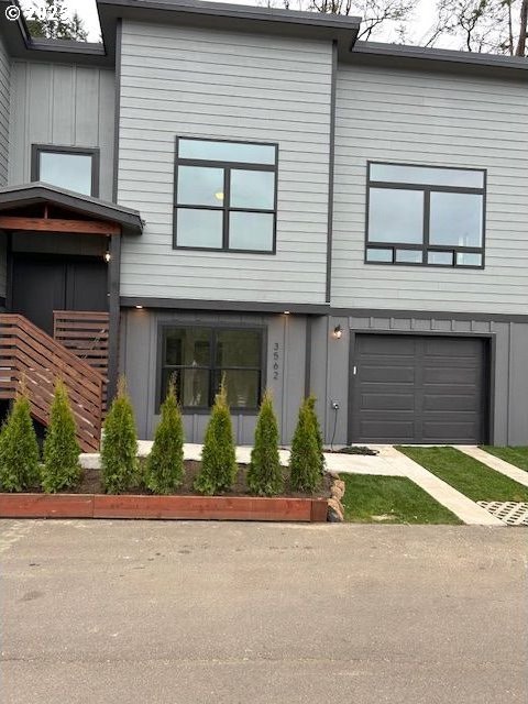 view of front facade with a garage, driveway, and board and batten siding