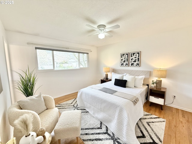 bedroom with a ceiling fan, baseboards, and wood finished floors