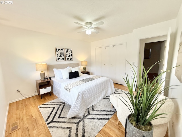 bedroom with light wood-style floors, a closet, and a ceiling fan