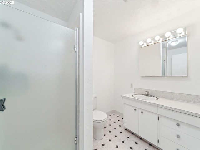 bathroom featuring toilet, tile patterned floors, baseboards, and vanity