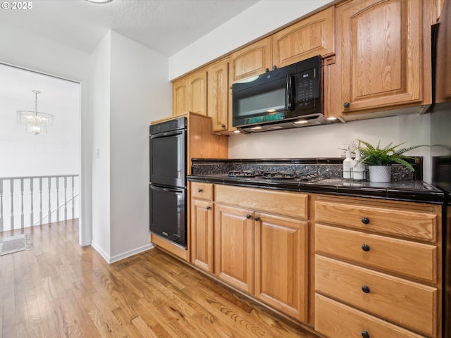 6325 SW Elm Ave, Beaverton, OR 97005 - kitchen with black appliances, light wood-type flooring, a chandelier, and baseboards