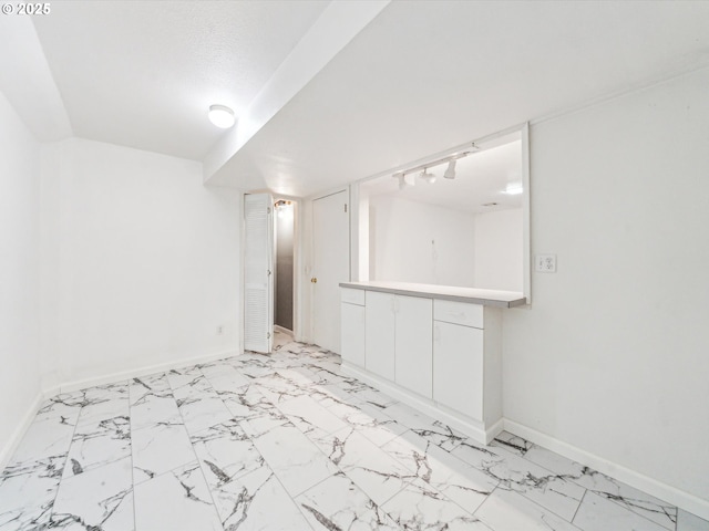 finished basement featuring marble finish floor and baseboards