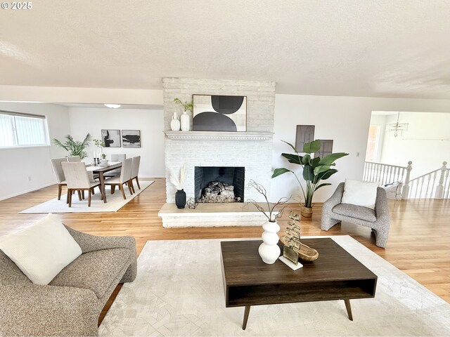 unfurnished living room featuring a fireplace, wood-type flooring, and a textured ceiling