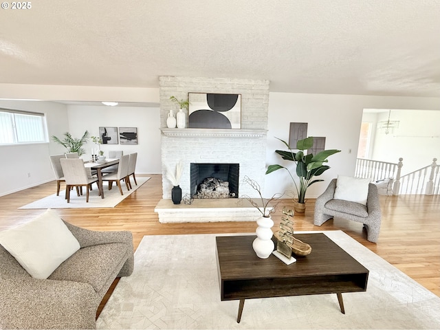 living room with a textured ceiling, a fireplace, and wood finished floors