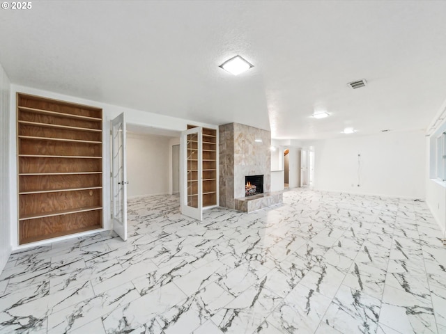 unfurnished living room featuring built in shelves and a premium fireplace