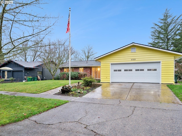 view of front facade featuring an attached garage, driveway, brick siding, and a front yard