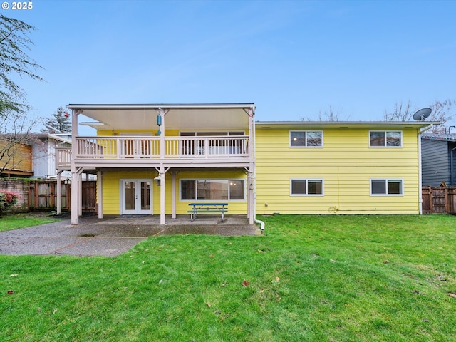 rear view of property featuring fence, french doors, a lawn, and a patio