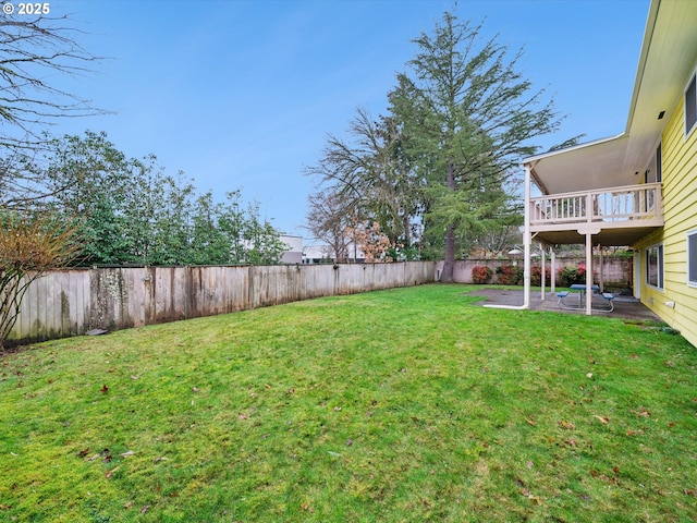 view of yard with a balcony, a patio area, and a fenced backyard