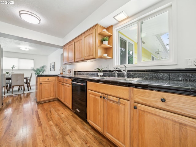 6325 SW Elm Ave, Beaverton, OR 97005 - kitchen with black dishwasher, a sink, healthy amount of natural light, and light wood finished floors