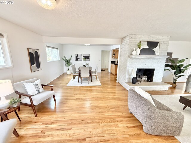 unfurnished living room featuring a textured ceiling and light hardwood / wood-style flooring