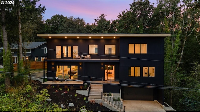 back house at dusk with a balcony