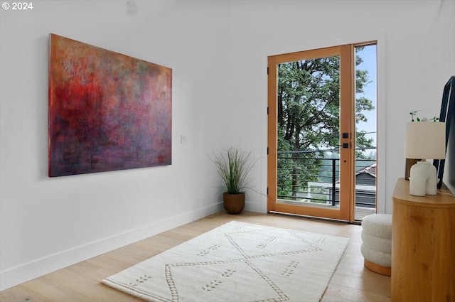 doorway with a healthy amount of sunlight and hardwood / wood-style flooring