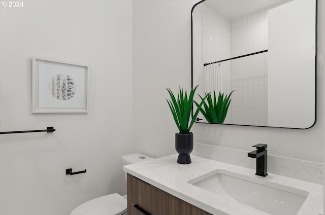 bathroom featuring curtained shower, vanity, and toilet