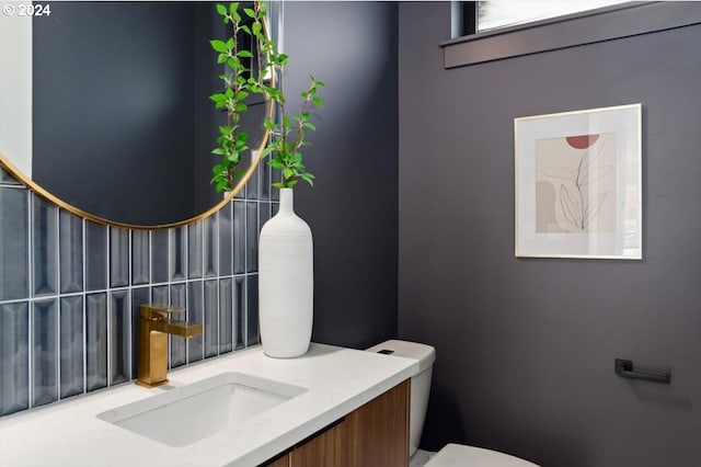 bathroom featuring backsplash, vanity, and toilet