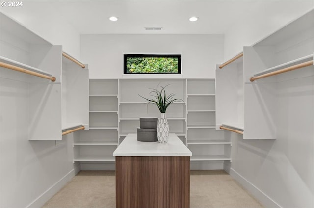 walk in closet featuring light colored carpet