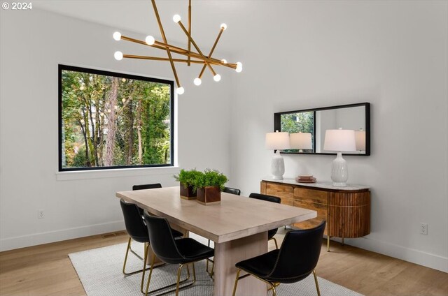 dining area featuring light wood-type flooring and a chandelier