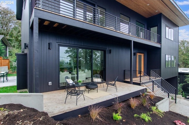 rear view of house with a patio and a balcony