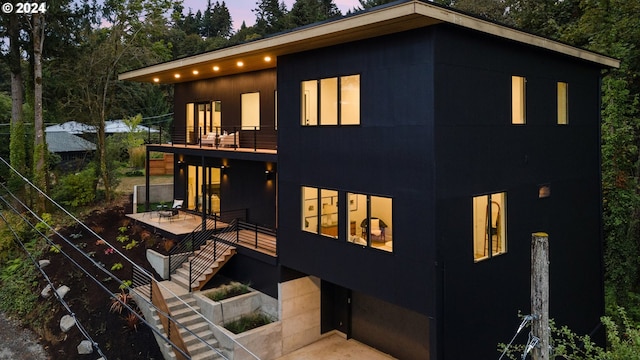 back house at dusk with a balcony