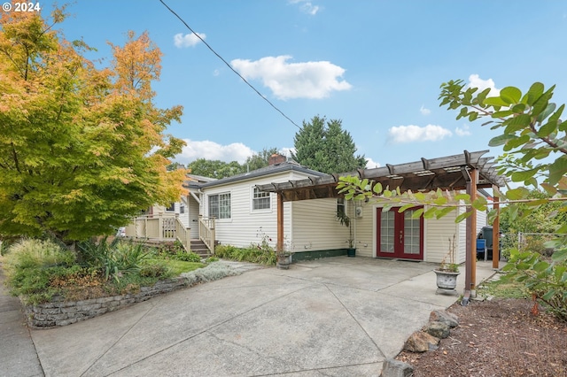 exterior space featuring a deck, a pergola, and french doors