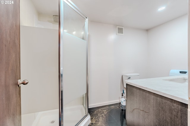 bathroom with vanity, toilet, and a shower with door