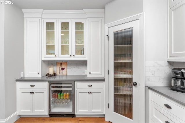 bar featuring wine cooler, tasteful backsplash, and a dry bar