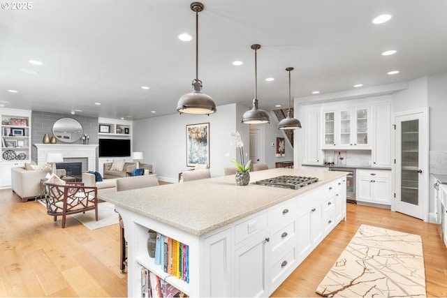 kitchen with a center island, wine cooler, recessed lighting, a fireplace, and light wood-style floors