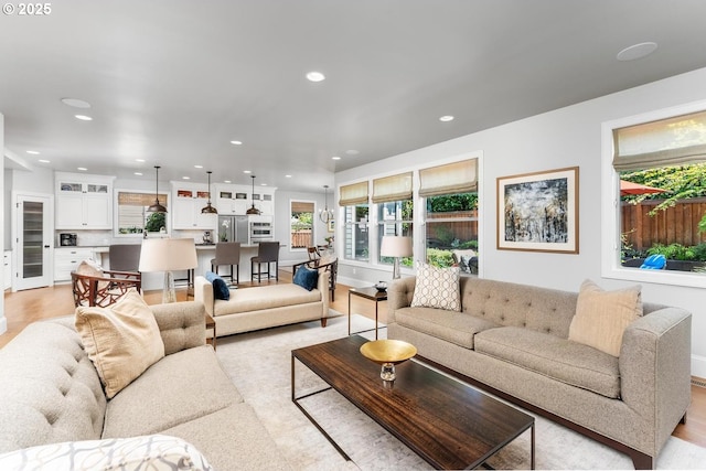 living area featuring recessed lighting, baseboards, and light wood finished floors