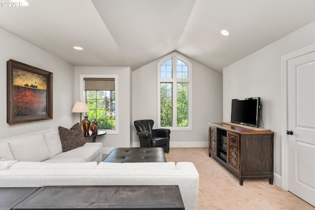 living room featuring plenty of natural light, light colored carpet, baseboards, and vaulted ceiling