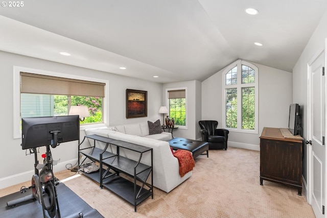 living area featuring lofted ceiling, light colored carpet, baseboards, and a wealth of natural light