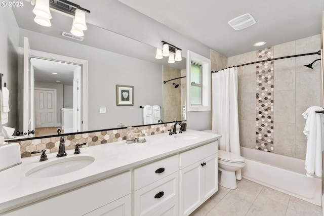 bathroom with tile patterned floors, shower / bath combo, visible vents, and a sink